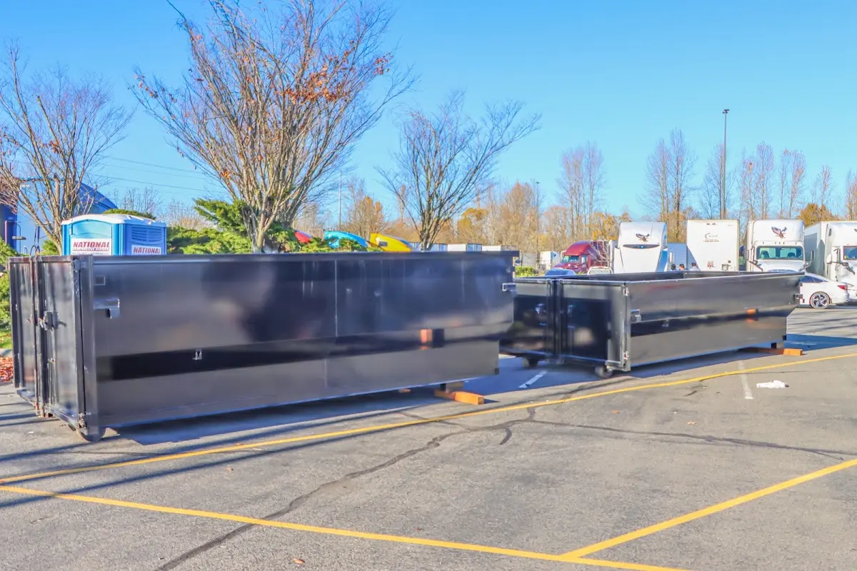 Professional dumpster rental service with roll-off container on residential driveway in South Valley